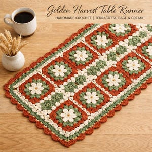 Peut inclure: Chemin de table en crochet fait main aux couleurs terracotta, sauge et crème. Le motif floral est orné de bords festonnés. Le texte "Golden Harvest Table Runner" est visible.