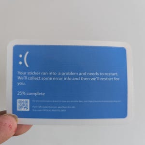 May include: A blue and white sticker with a sad face emoticon and the text "Your sticker ran into a problem and needs to restart. We'll collect some error info and then we'll restart for you. 25% complete". The sticker also includes a QR code and the text "For more information about this issue and possible fixes, visit https://marthartsandesugu.com. If you call a support person, give them this info. Stop code: CRITICAL PROCESS DIED."