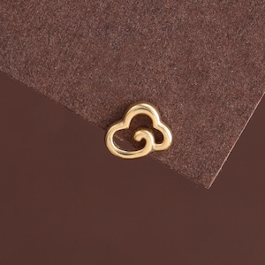 May include: A small gold-toned stud earring shaped like a stylized cloud with a smooth, polished finish. The earring features a continuous, rounded outline that forms a cloud silhouette with a small, circular cutout detail in the center.