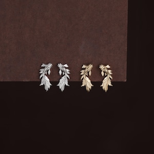 May include: Two pairs of stud earrings shaped like koi fish, one pair in a polished silver tone and one pair in a polished gold tone. Each earring features detailed scales and flowing fins, capturing the swimming motion of the fish in metal.
