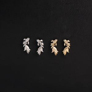 May include: Four stud earrings shaped like koi fish, arranged in a row. The two earrings on the left are silver-toned with detailed fins and scales, while the two earrings on the right are gold-toned with the same intricate fish design.