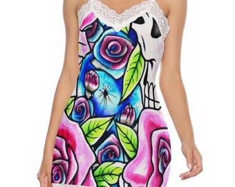 May include: A white slip dress with a colorful floral and skull print. The dress features a V-neckline and hemline trimmed with white lace. The floral design includes pink and blue roses with green leaves.