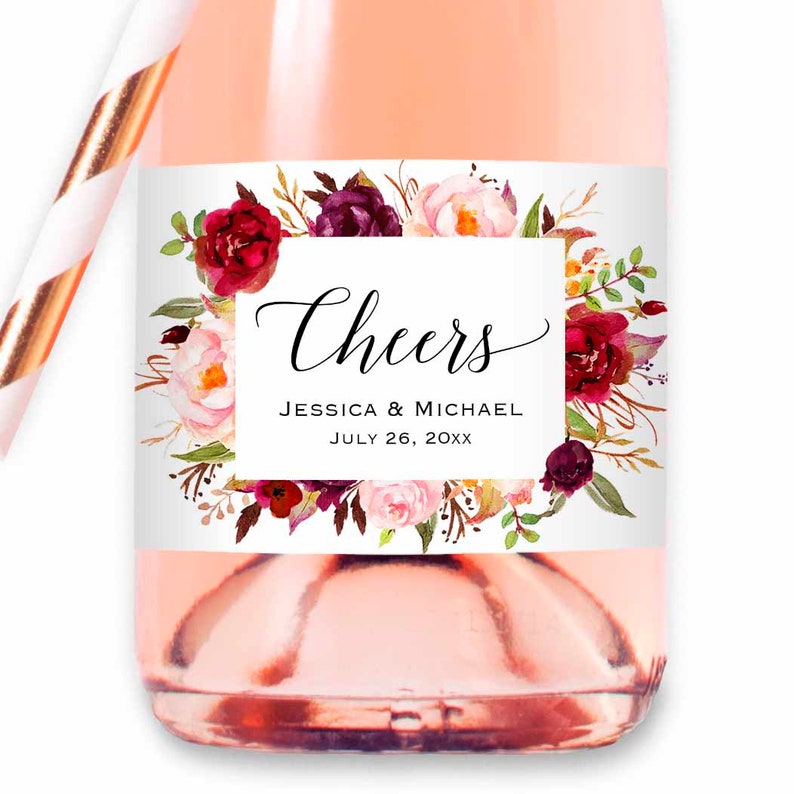 Pu&ograve; includere: Un'etichetta per bomboniere di matrimonio bianca con una ghirlanda floreale bordeaux e rosa. L'etichetta dice "Cheers Jessica & Michael July 26, 20XX".