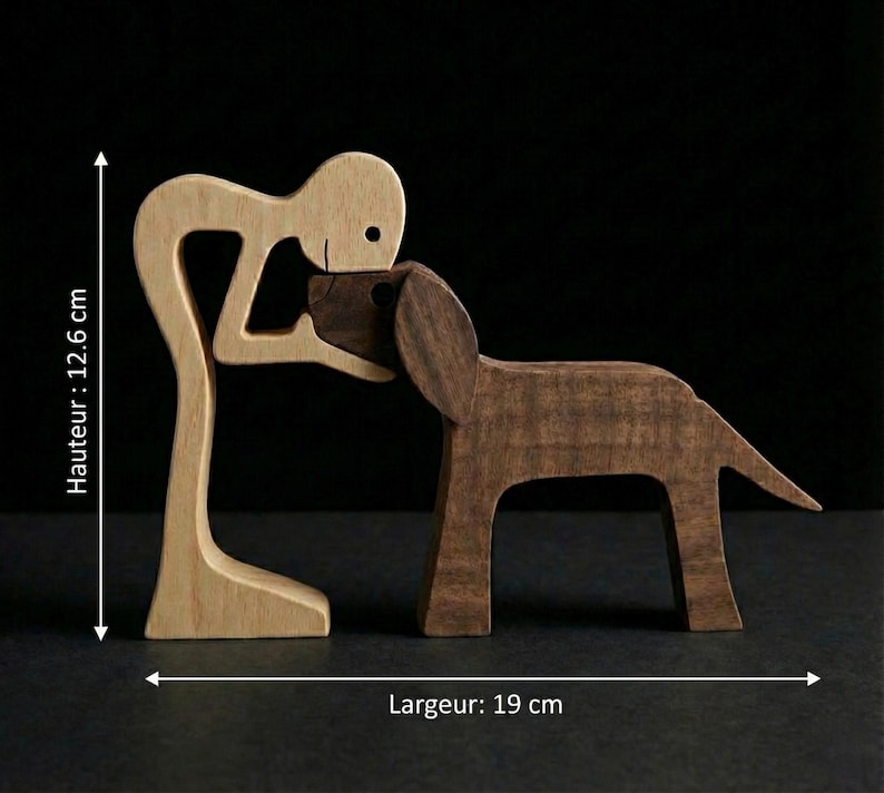 May include: A wooden sculpture depicting a person embracing a dog. The person is light-colored wood, while the dog is a darker brown. The sculpture is approximately 5 inches tall and 7.5 inches wide, showcasing a loving bond.