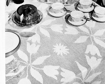 May include: A black and white photo of a crocheted tablecloth with a tulip design. The tablecloth is set with a cake, teacups, and a teapot. The text "FILET Tablecloth IN TULIP DESIGN" and "DIRECTIONS ON PAGE 15" is printed below the image.