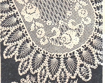 May include: A vintage, cream-colored, crocheted doily with an oval center and intricate floral and leaf patterns. The doily is set against a dark background, highlighting the delicate openwork design. The image showcases the detailed craftsmanship of the handmade textile.