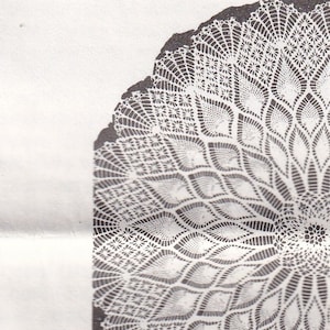 May include: An illustration of a dining room scene featuring a round table covered with a detailed, lacy tablecloth. The image is in black and white, with a large, decorative lace element at the top, suggesting a curtain or a similar textile.