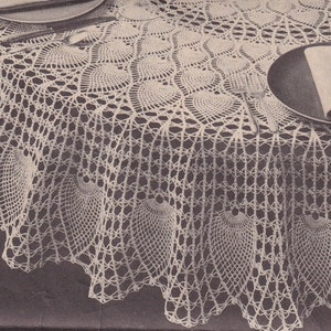 Puede incluir: Un mantel de crochet blanco con un borde festoneado y un delicado patrón floral. El mantel está puesto sobre una mesa redonda con vasos, platos y fruta encima.