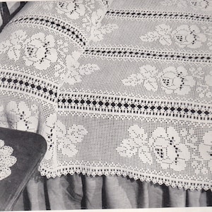 May include: White crocheted bedspread with a floral pattern. The bedspread has a scalloped edge and a diamond-shaped border.