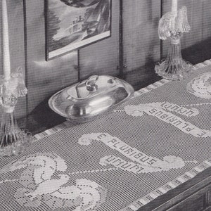 Pode incluir: Um corredor de mesa de crochê com fundo branco e um delicado design floral. O corredor apresenta as palavras "Bem-vindo" e "Nós Fazemos a Sua Instalação Hidráulica" em uma fonte de escrita cursiva. O corredor é exibido em uma mesa de madeira com uma travessa de servir de prata e dois castiçais de cristal.