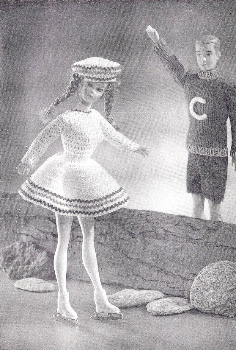May include: A black and white photo of two dolls. The doll on the left is wearing a white crocheted dress with a black and white trim, a white crocheted hat, and ice skates. The doll on the right is wearing a dark sweater with a white letter C on the front and dark pants.