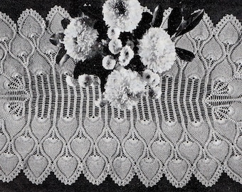 May include: A white crocheted table runner with a peacock feather design. The runner features a series of delicate, scalloped edges and intricate lacework.