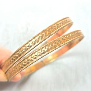 Paire de bracelets joncs empilables dorés... Fins en métal texturé... Ton doré foncé