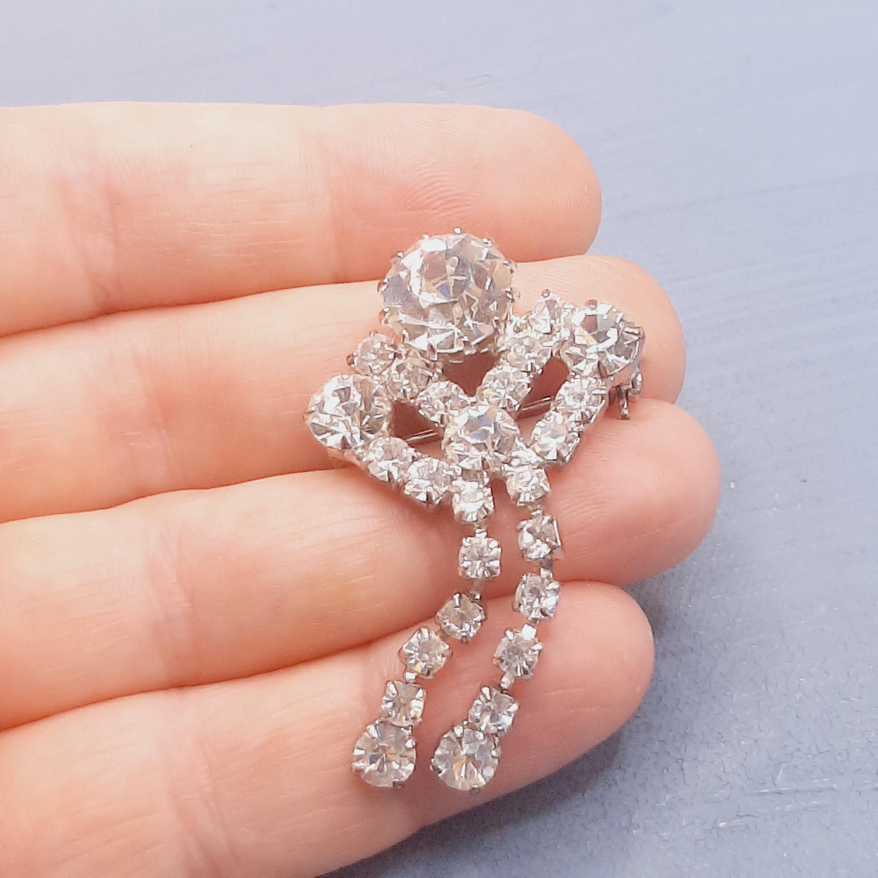 Broche vintage formant ruban noué en rivière de strass à pampilles