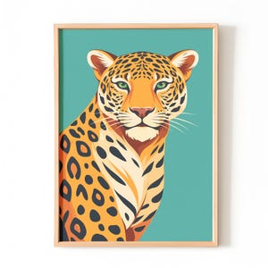 May include: A framed art print featuring a stylized illustration of a jaguar. The jaguar has orange fur with black spots, green eyes, and a pink nose. The background is a teal color, and the frame is a light brown.