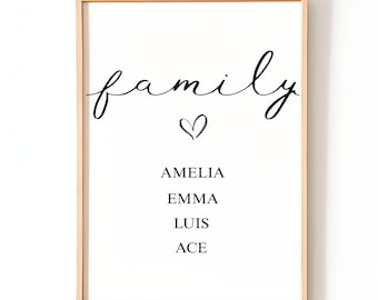 Puede incluir: Impresión enmarcada con la palabra "familia" en escritura cursiva, un símbolo de corazón y los nombres Amelia, Emma, Luis y Ace. El marco es de madera clara y el fondo es blanco. Decoración de pared.