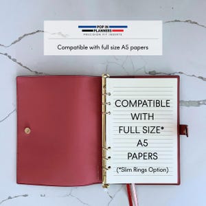 May include: A dusty rose planner binder with a gold six-ring mechanism, featuring a snap closure and white lined paper. The text reads: POP IN PLANNERS PRECISION FIT INSERTS, Compatible with full size A5 papers, COMPATIBLE WITH FULL SIZE* A5 PAPERS (*Slim Rings Option).