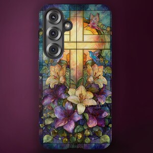 May include: A rectangular phone case featuring a stained glass design with a central cross, vibrant lilies in shades of purple, yellow, and white, and two small hummingbirds. The design includes a grid pattern and the text Texorjun Bayou Cards.