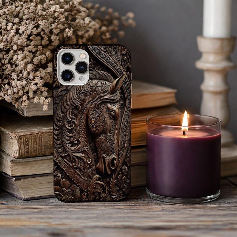 Peut inclure: Une coque de smartphone pr&eacute;sentant une sculpture en relief tridimensionnelle brun fonc&eacute; repr&eacute;sentant une t&ecirc;te de cheval. Le motif comprend des d&eacute;tails floraux et des volutes complexes autour du cheval, avec une d&eacute;coupe pour l'appareil photo.