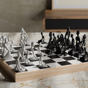 May include: A unique chess set with abstract, human-like figures. The pieces are split into two teams, white and black, and are arranged on a checkered board. The board is set on a wooden base, creating a modern aesthetic.