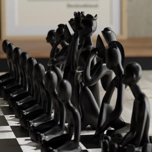 May include: A black chess set with uniquely designed pieces. The pieces are stylized human figures in various poses, set on a black and white checkered board. The background includes a framed artwork with a red circle.