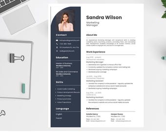 May include: A professional resume template with a photo of a woman, titled "Sandra Wilson, Marketing Manager." The resume includes sections for contact information, education, skills, and work experience, with a clean, modern design. A notebook, keyboard, and accessories are on the white surface.