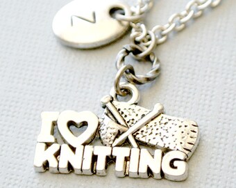 Puede incluir: Collar de plata con un dije que dice "Me encanta tejer" con un corazón, agujas de tejer e hilo. El collar también tiene un dije ovalado de plata con la letra "Z" en él.
