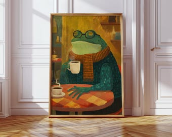 May include: A framed art print depicts a frog wearing glasses and a scarf, seated at a table with a cup of coffee. The frog is green, the scarf is orange, and the table is red and orange. The background is a warm, yellow-toned cafe setting.