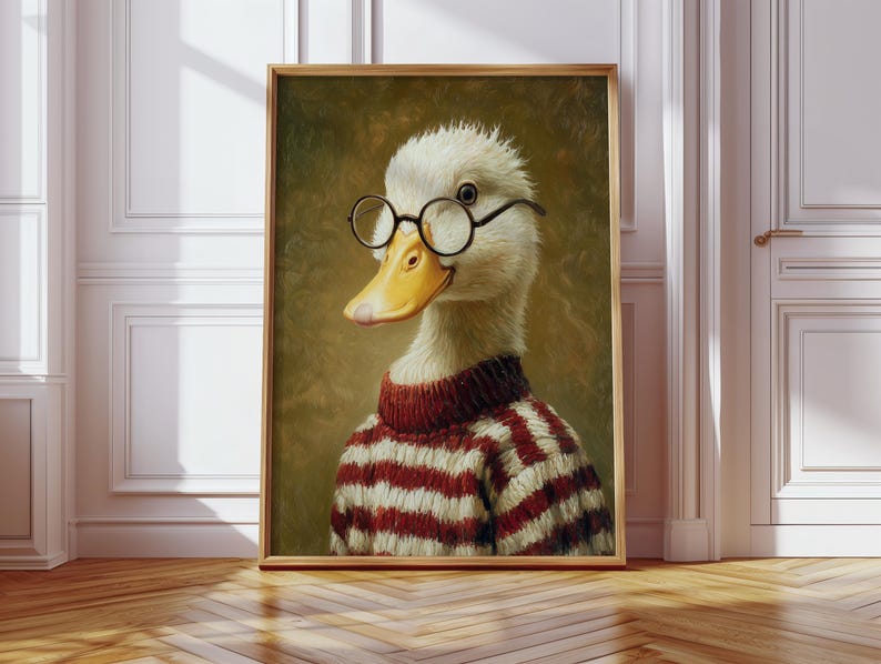 Op de afbeelding: Ingelijst kunstwerk met een eend met een ronde bril en een rood-witte gestreepte trui. De eend heeft een gele snavel en staat tegen een gedempte groene achtergrond. Het kunstwerk zit in een houten lijst.