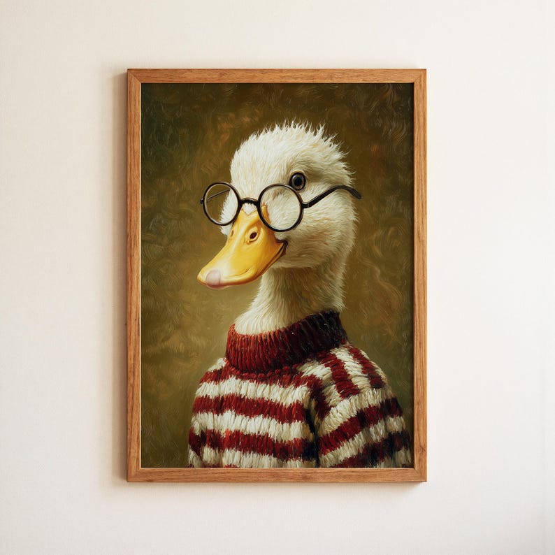 Op de afbeelding: Een ingelijst portret van een eend met een ronde bril en een rood-witte gestreepte trui. De eend heeft een gele snavel en glimlacht. Het kunstwerk staat tegen een gedempte groene achtergrond.