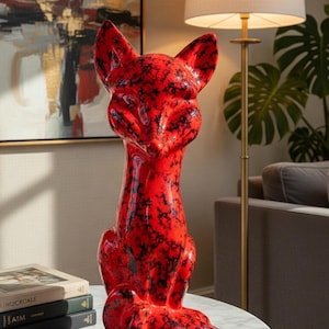 May include: A white ceramic mug with a black handle and the text "But First, Coffee" in a black, bold font. The mug is sitting on a white surface. The mug is approximately 4 inches tall.