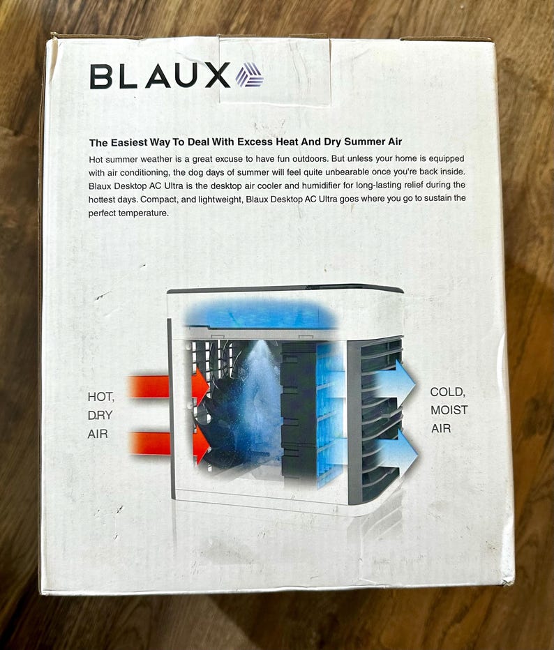 Puede incluir: Una caja blanca con el nombre de la marca "BLAUX" en letras negras. La caja presenta un diagrama de un enfriador de aire y humidificador de escritorio, con etiquetas que indican "AIRE CALIENTE Y SECO" y "AIRE FR&Iacute;O Y H&Uacute;MEDO".