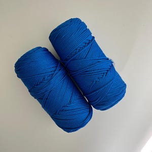 May include: Two spools of bright blue yarn.