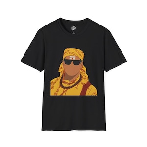 May include: Black t-shirt featuring a graphic of a person wearing sunglasses, a yellow head covering, and a yellow shirt with a necklace. The graphic has a minimalist design with bold colors and lines.