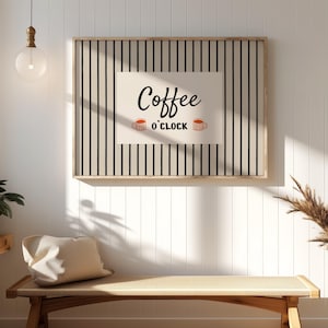 Puede incluir: Una taza de cerámica blanca con asa negra y el texto "But First, Coffee" en negro, con una fuente de estilo manuscrito. La taza está sobre una superficie blanca.
