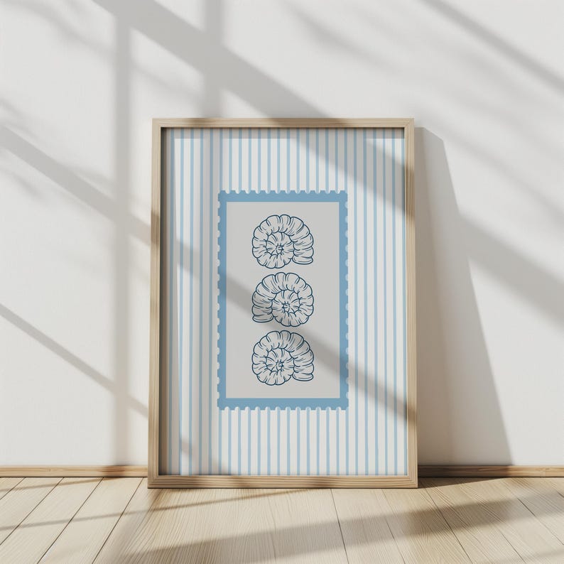 May include: A framed print featuring three stylized nautilus shell illustrations in a vertical arrangement. The shells are dark blue on a light gray background within a blue postage stamp-style border. The background has vertical blue stripes.
