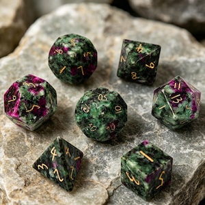 May include: Set of seven gemstone dice in various shapes, including a d4, d6, d8, d10, d12, d20, and a d10 percentile die. The dice are green with red inclusions and gold numbering. The dice are displayed on a gray stone surface.