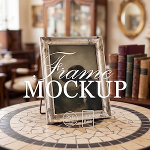 May include: A silver-framed picture with the text "Frame MOCKUP" is displayed on a mosaic-tiled table. The frame has a distressed, vintage look. The image inside the frame is a dark painting. The background is a blurred interior.