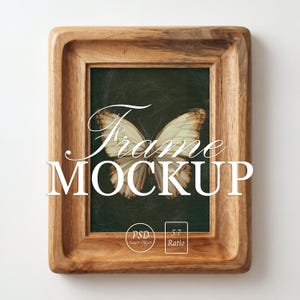 Op de afbeelding: Een rechthoekige houten fotolijst met een natuurlijke houtnerfafwerking, met een donkergroene achtergrond en een gecentreerde vlinderillustratie. De tekst "Frame MOCKUP" is in het wit over de afbeelding geplaatst, samen met "PSD Smart Object" en "5:7 Ratio" iconen.