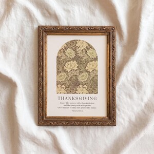 May include: A framed print with the word "THANKSGIVING" and a floral design in a gold frame. The print includes text from Psalm 100:4. The frame has an ornate, vintage style.