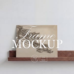 May include: A framed art print mockup featuring a detailed illustration of a pine tree branch. The artwork is displayed on a wooden shelf against a white wall. The text "Frame MOCKUP" is overlaid on the image, along with icons indicating PSD and a 5:4 ratio.
