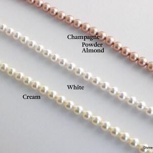 K&ouml;nnte beinhalten: Drei Str&auml;nge aus runden Perlen, die diagonal angeordnet sind. Der oberste Strang ist champagner-, puder- und mandelfarben. Der mittlere Strang ist wei&szlig;. Der untere Strang ist cremefarben. Der Text "Champagne Powder Almond", "White", "Cream" und "Divine Jewel" ist sichtbar.