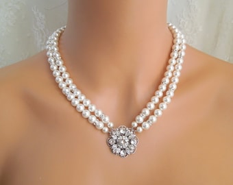 Op de afbeelding: Een dubbele rij parelketting met een zilveren bloemhanger met kristallen.