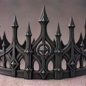Peut inclure: Une couronne noir mat présentant une série de hautes flèches pointues et de découpes en arc. Le design comprend des accents géométriques en forme de losange et des motifs circulaires intégrés dans la structure verticale, créant un motif répétitif.