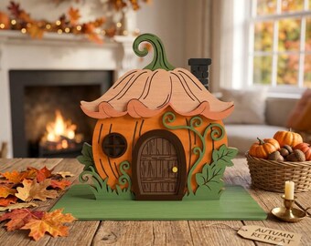 May include: A decorative wooden pumpkin-shaped house featuring a curved green stem roof, a central arched brown door with a yellow knob, a small circular window, and green leaf accents on a flat green base, with a tag labelled AUTUMN RETREAT.