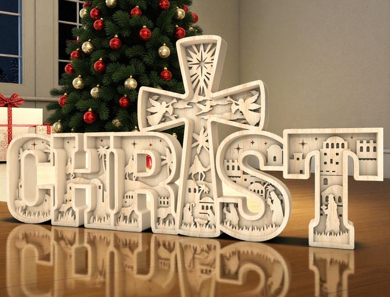 May include: A wooden Christmas decoration spelling out the word "CHRIST" with a cross. The letters and cross are intricately carved with religious scenes. A Christmas tree with red and gold ornaments is in the background.
