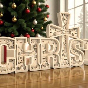 May include: A wooden Christmas decoration spelling out the word "CHRIST" with a cross above the "T". The letters and cross are intricately carved with a nativity scene and palm trees. A Christmas tree with ornaments is in the background.