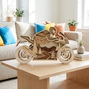 Peut inclure: Une décoration murale en bois multicouche en forme de moto sportive. Le design découpé présente un conducteur avec un casque, une route sinueuse, des pins et des silhouettes de montagnes dans diverses nuances de bois brun, beige et crème.