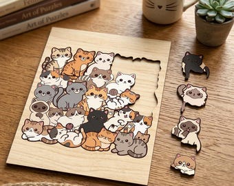 May include: A wooden jigsaw puzzle featuring a collection of cartoon cats in various colors and patterns. The puzzle is partially assembled, with several cat-shaped pieces placed nearby. A mug with cat whiskers and a small potted succulent are also visible.