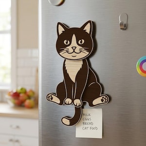 May include: A wooden cat-shaped magnet with a brown and cream color scheme, attached to a refrigerator. The cat is sitting with its tail curled. A small notepad with a grocery list is attached below the magnet.